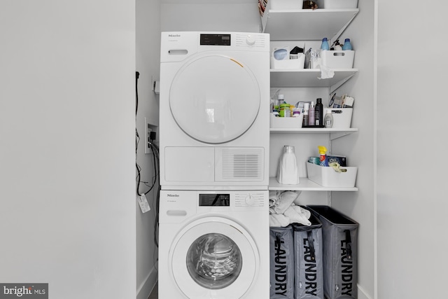 washroom with stacked washing maching and dryer