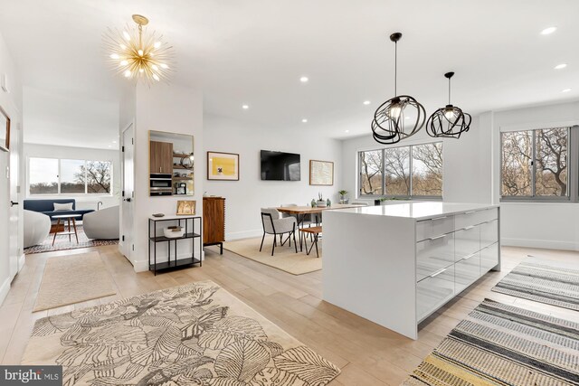 kitchen featuring light wood-style flooring, recessed lighting, a large island, modern cabinets, and a chandelier