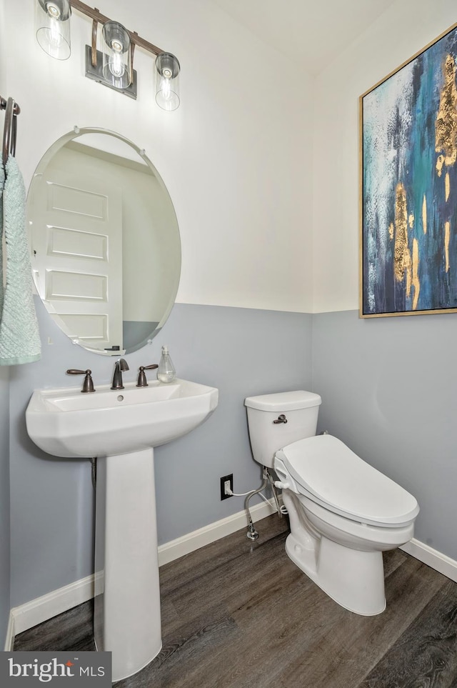 bathroom featuring baseboards, toilet, and wood finished floors