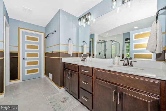 bathroom featuring a shower stall, double vanity, tile patterned floors, and a sink