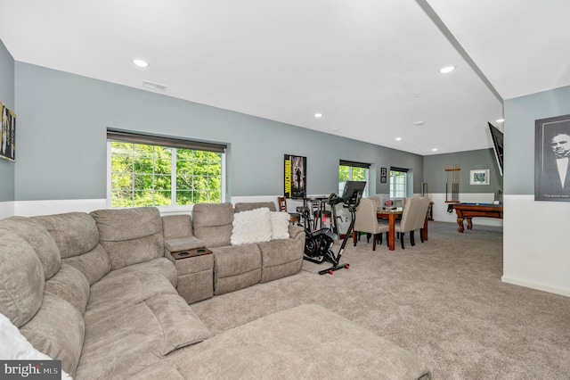 carpeted living area with a wealth of natural light, visible vents, baseboards, and recessed lighting