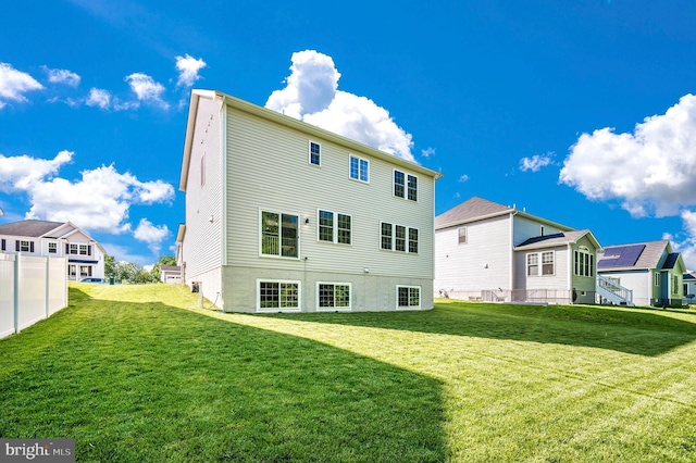 back of property with a residential view and a lawn