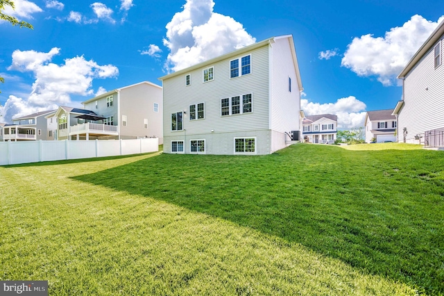 back of property featuring a yard, fence, and a residential view