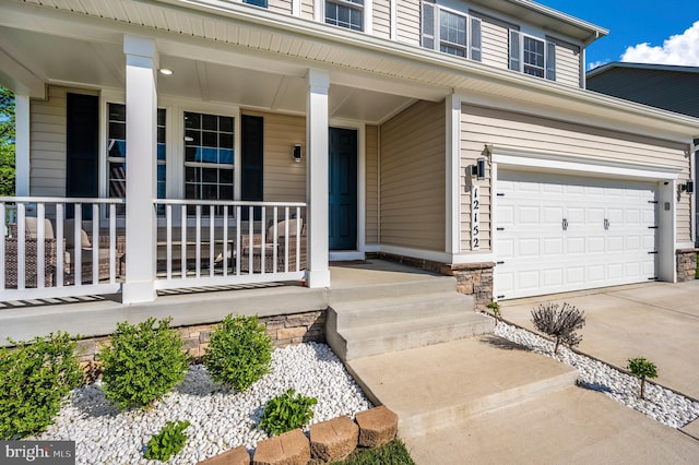 view of exterior entry featuring a porch and driveway