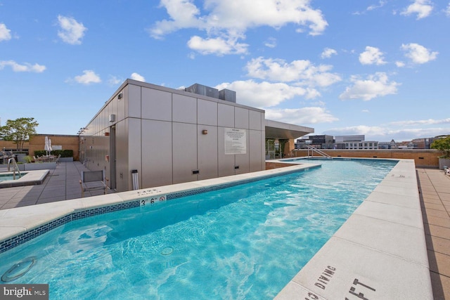 pool with a patio and fence