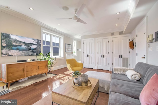 living area with baseboards, wood finished floors, and ornamental molding