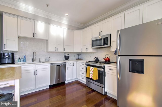 kitchen with a sink, appliances with stainless steel finishes, white cabinets, and light countertops