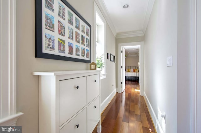 corridor featuring dark wood-type flooring, baseboards, and ornamental molding