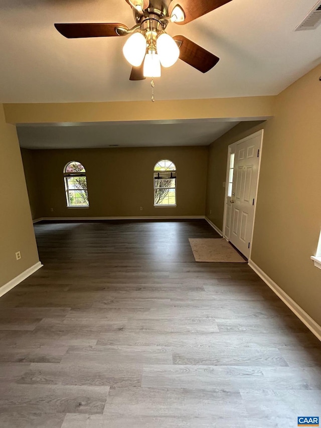 foyer entrance featuring a wealth of natural light, visible vents, baseboards, and wood finished floors