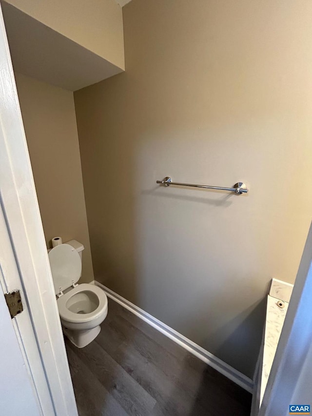 bathroom featuring toilet, baseboards, and wood finished floors