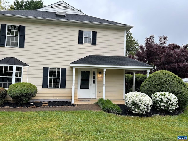 view of front of home featuring a front yard and roof with shingles