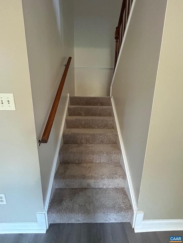 stairway with baseboards and wood finished floors