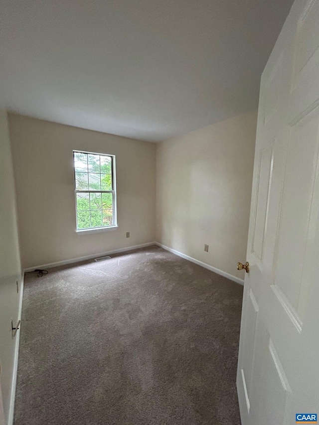 unfurnished room featuring baseboards and carpet