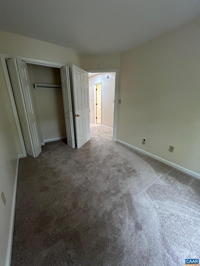 unfurnished bedroom with a closet, baseboards, and carpet floors