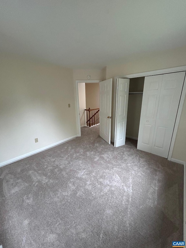 unfurnished bedroom with a closet, baseboards, and carpet