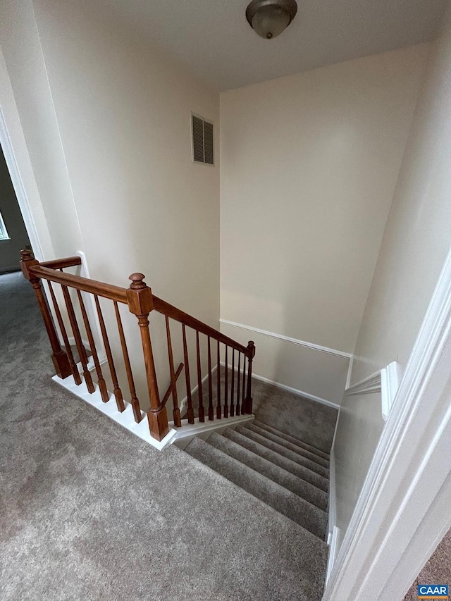 stairway with visible vents and carpet flooring