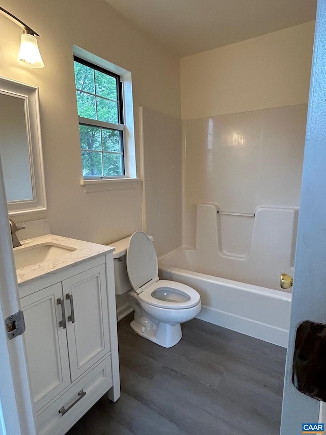 bathroom with vanity, shower / tub combination, toilet, and wood finished floors