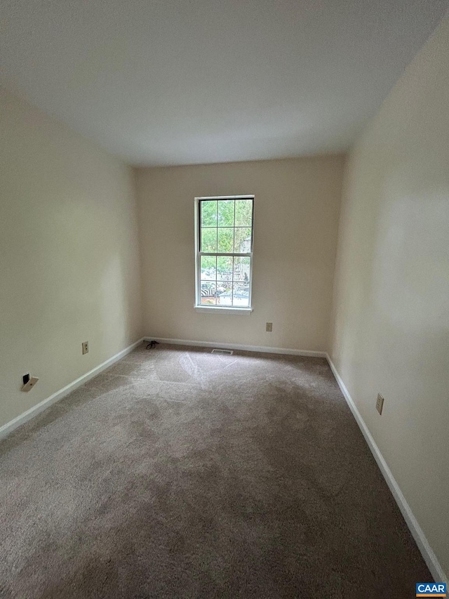 carpeted empty room featuring baseboards