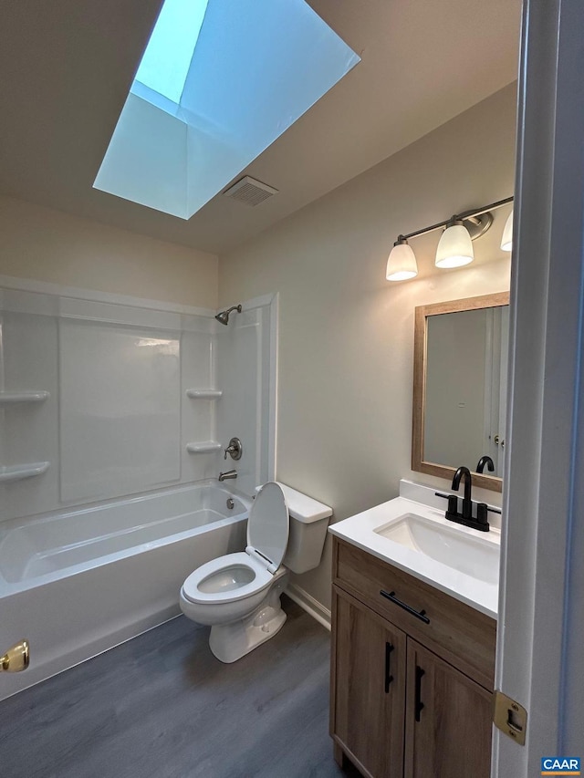 full bathroom featuring wood finished floors, visible vents, a skylight, bathing tub / shower combination, and toilet