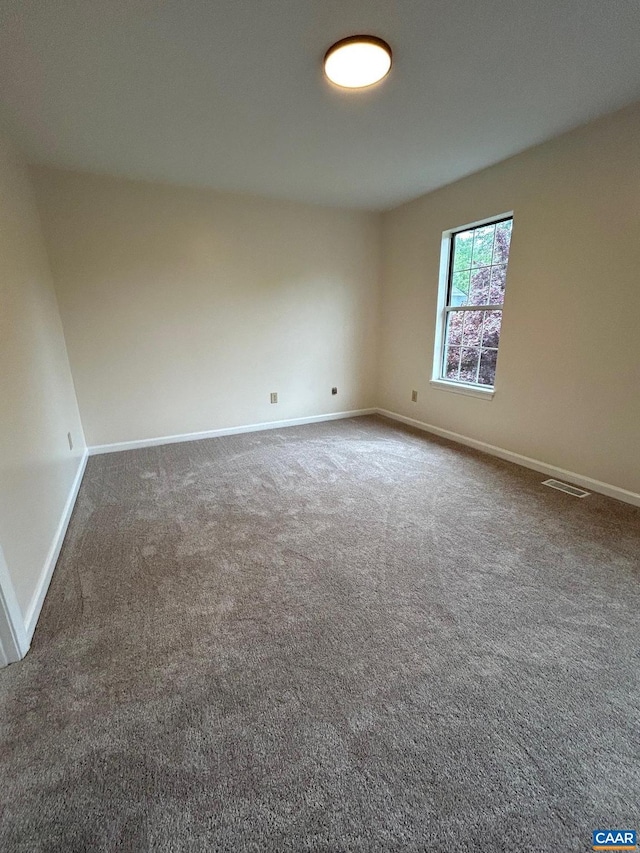 unfurnished room featuring carpet flooring, baseboards, and visible vents