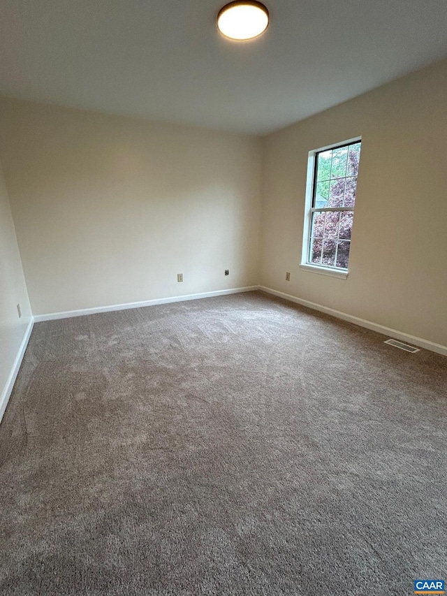 carpeted empty room with visible vents and baseboards