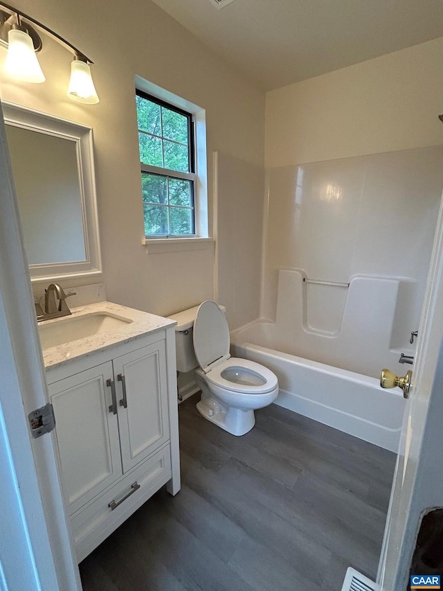 full bath featuring shower / bathtub combination, toilet, vanity, and wood finished floors