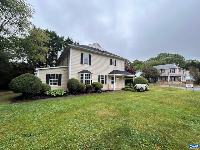 view of front of home featuring a chimney and a front lawn