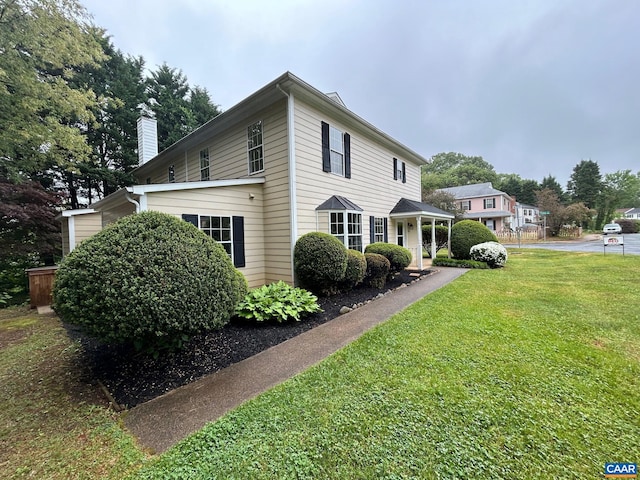 view of home's exterior featuring a lawn and a chimney