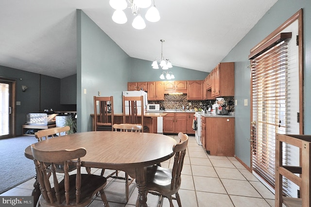 dining room with lofted ceiling, an inviting chandelier, light tile patterned floors, and a wealth of natural light