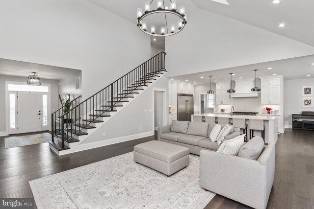 286 Claremont Ave, Harrisonburg, VA 22801 - living area with dark wood-type flooring, high vaulted ceiling, a notable chandelier, stairway, and baseboards