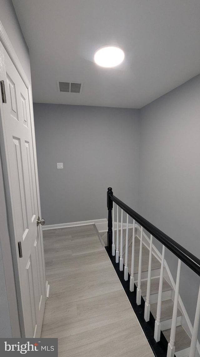 stairs with visible vents, baseboards, and wood finished floors