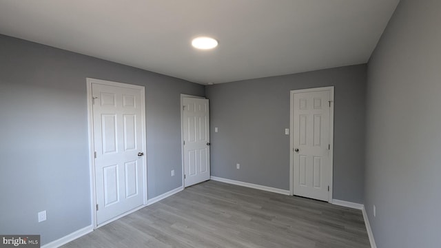 unfurnished bedroom with baseboards and wood finished floors