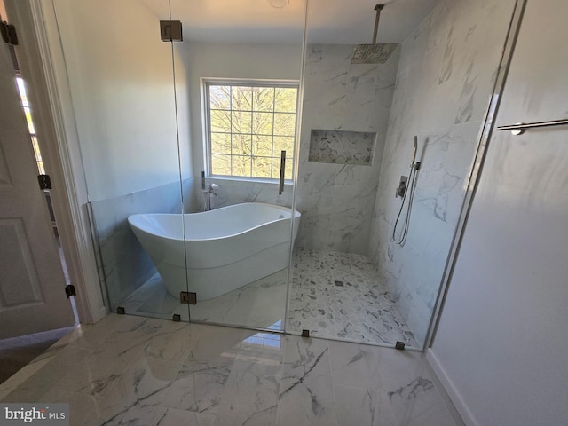 bathroom with a marble finish shower, marble finish floor, and a freestanding bath