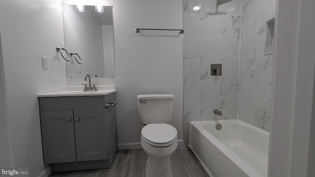 full bathroom featuring toilet, wood finished floors, shower / bathing tub combination, baseboards, and vanity