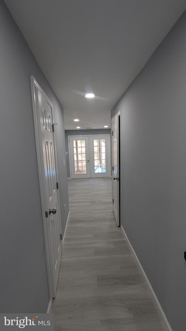 hallway featuring baseboards and light wood-type flooring