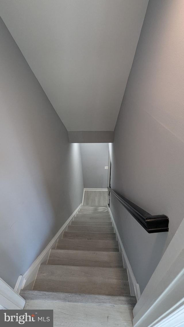 staircase with wood finished floors and baseboards