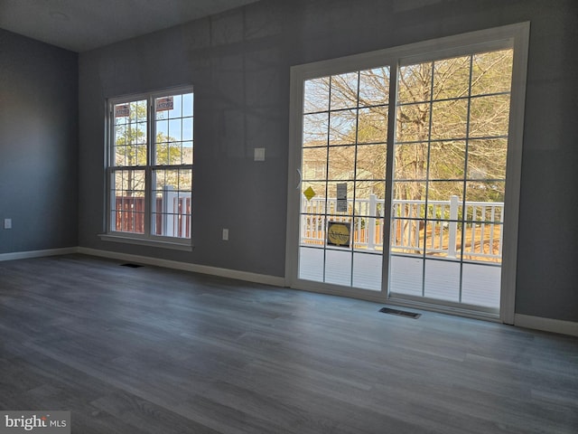 interior space featuring visible vents, dark wood-type flooring, and baseboards