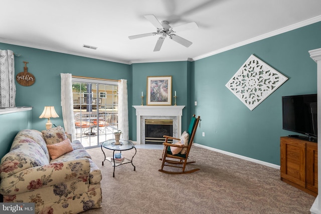 carpeted living area featuring baseboards, visible vents, a fireplace, ceiling fan, and ornamental molding