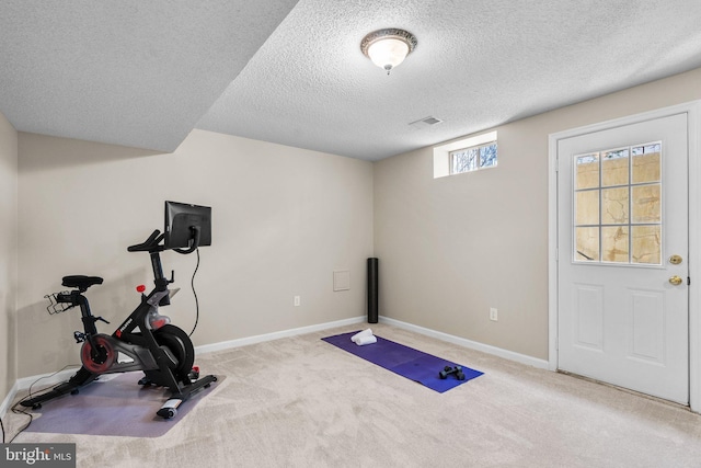 workout room featuring visible vents, baseboards, carpet floors, and a textured ceiling