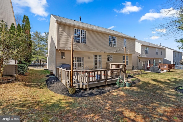 rear view of house featuring a yard, central air condition unit, and a deck