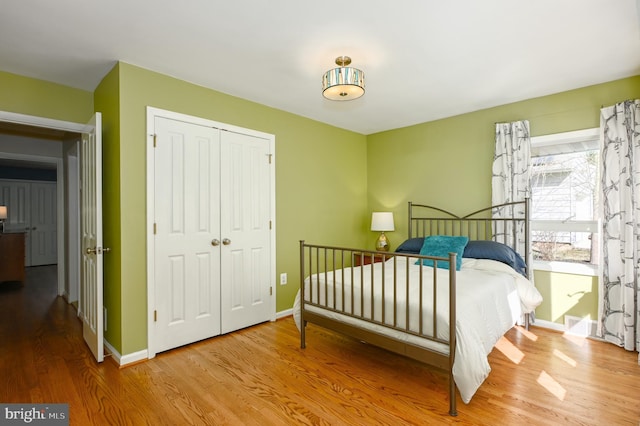 bedroom featuring a closet, baseboards, and wood finished floors