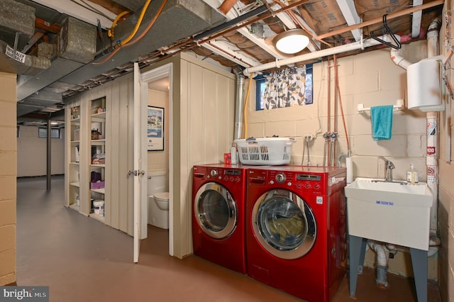 washroom with a sink, laundry area, and washing machine and clothes dryer