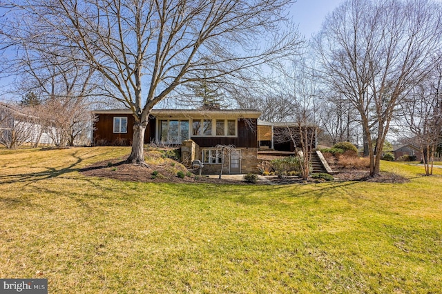 rear view of property featuring a yard, a chimney, and stairs