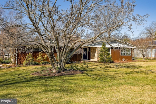 view of front facade featuring a front lawn and stone siding