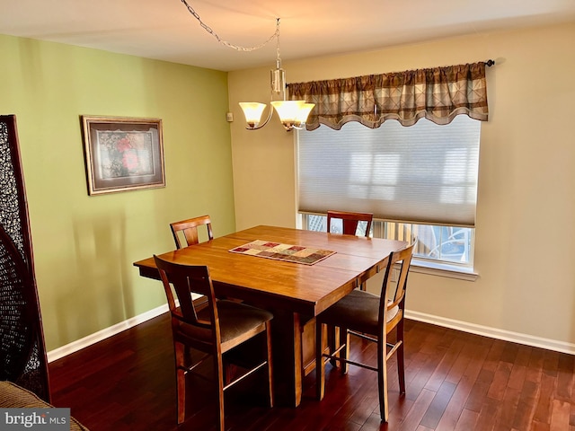 dining area with dark wood finished floors, a chandelier, and baseboards