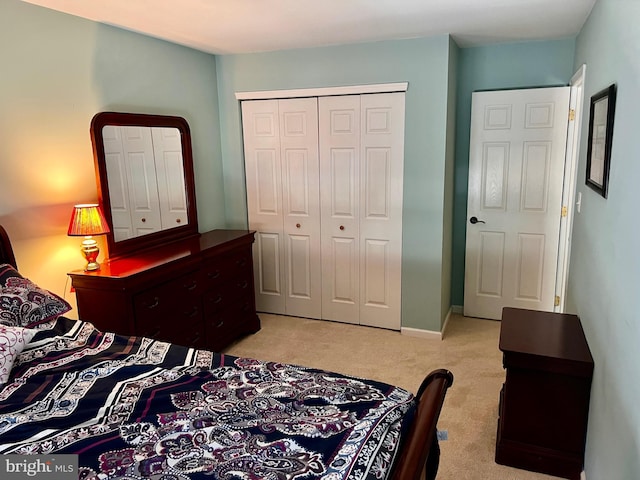 bedroom with a closet, light carpet, and baseboards