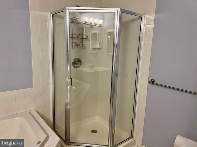 bathroom with a shower stall and a garden tub