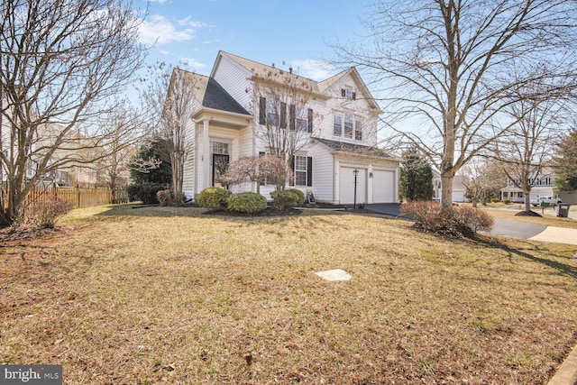 view of front of home featuring a garage, driveway, a front lawn, and fence