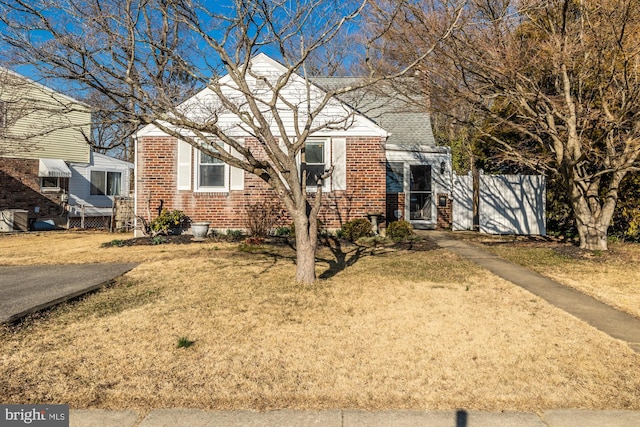 view of front of house with a front yard and brick siding