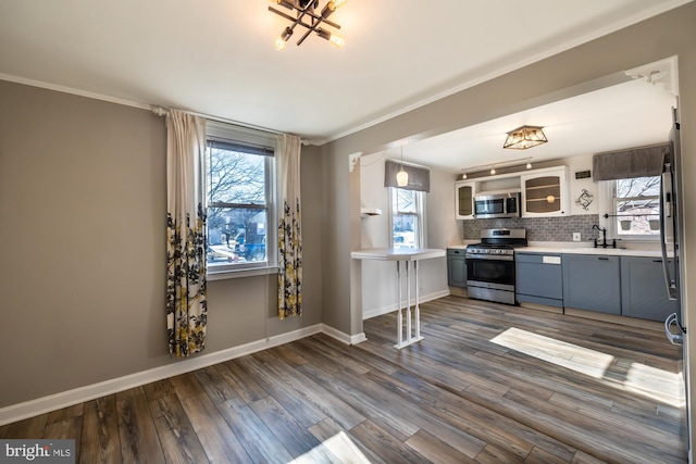 kitchen featuring decorative backsplash, dark wood-type flooring, light countertops, and appliances with stainless steel finishes